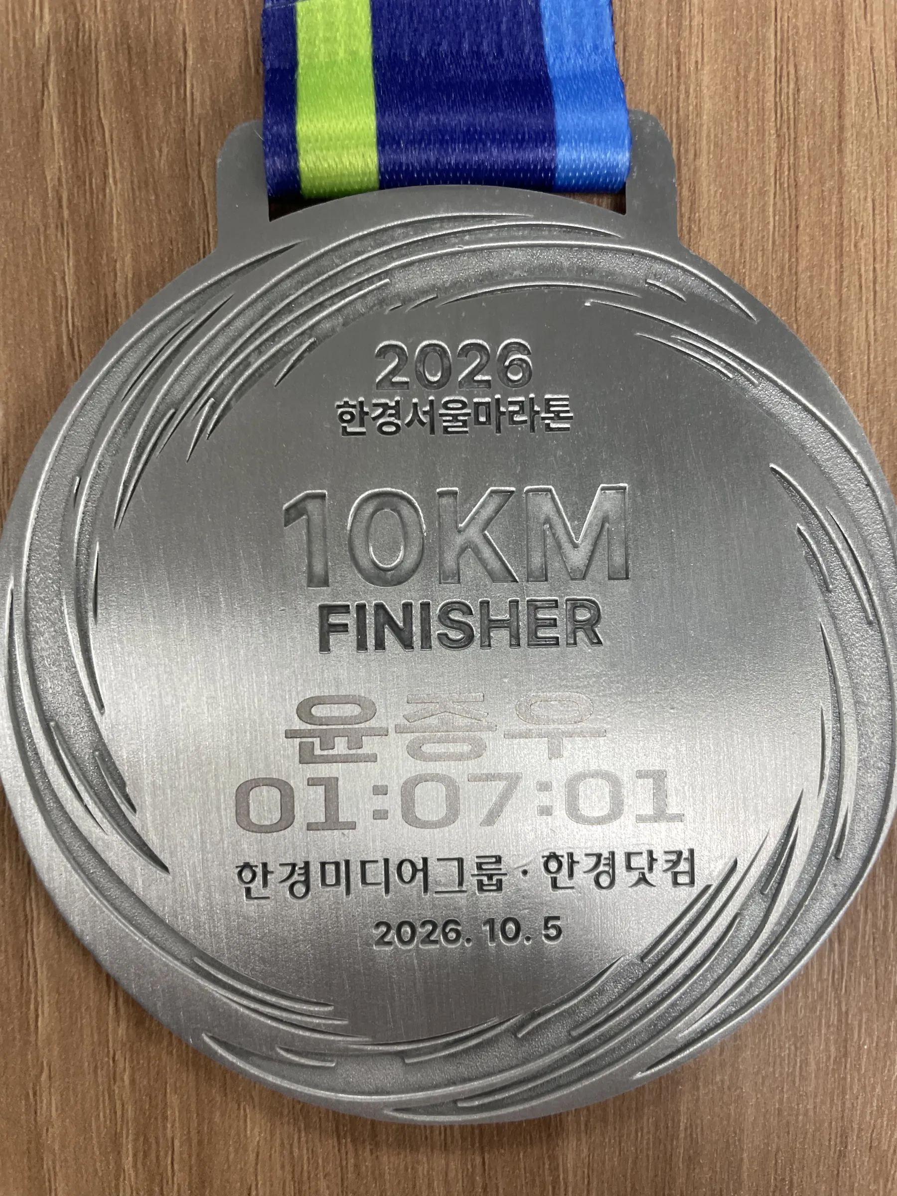 2026 한경서울마라톤 10KM FINISHER 메달 뒷면 — 윤종우 01:07:01